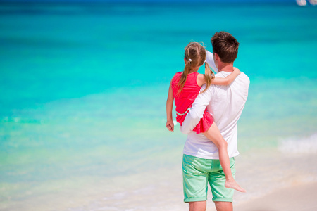 小女孩和年轻父亲在热带海滩度假