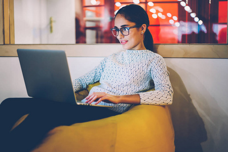 积极的黑发时髦女孩休息在 coworking 空间看电影在笔记本电脑上, 积极的女性自由职业者享受赚钱在线打字上网本出版物网页