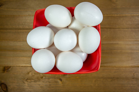 一组鸡蛋在一个深红色的碗里等待厨师在一餐中使用它们