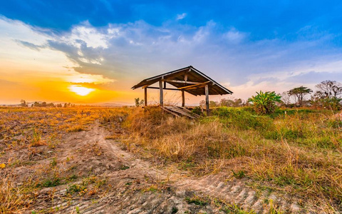 美丽的乡村夕阳与旱稻场和小屋在收获的季节