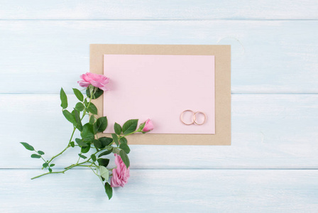 粉红玫瑰和与纸质贺卡婚礼新娘戒指