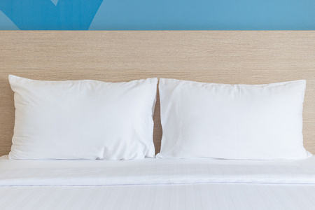 白色的床单和枕头在酒店的房间里
