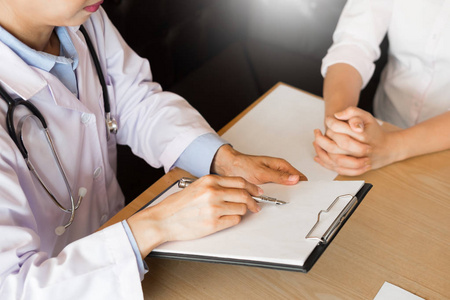 医生解释病人的症状或问一个问题,当他们一起讨论了文书工作中的咨询