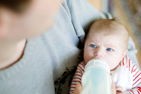 父亲与护理瓶中的牛奶喂养刚出生的婴儿女儿