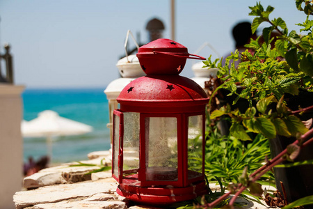 红色小灯笼作为装饰在海岸餐馆. 能在舒适的室外咖啡馆用小灯笼和植物装饰。阳台上的餐厅或咖啡馆