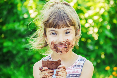 一个可爱的孩子吃巧克力。选择性对焦。自然