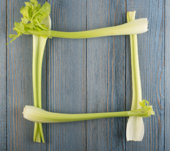 原绿芹菜茎在木质背景的顶部视图。copyspace 旧木乡土餐桌新鲜有机方形蔬菜框架