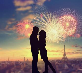 与埃菲尔铁塔和巴黎在背景上的烟花的浪漫情侣的剪影照片