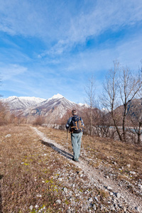 背包和竿徒步行走在河岸边往山