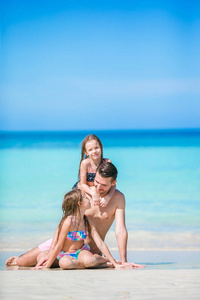 父亲和孩子们享受海滩的暑假