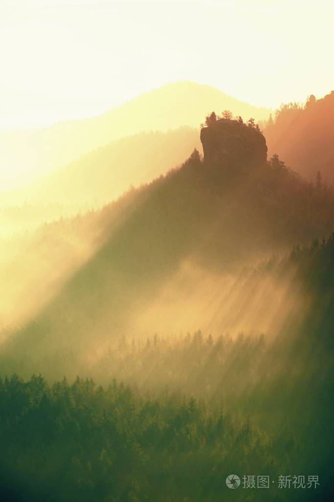 捷克萨克森瑞士美丽山的日出。尖山雾的背景，从增加雾是由于太阳光的橙色