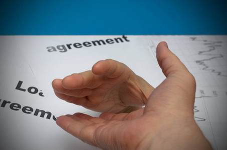 一只手通过报纸得到帮助与另一方面照片