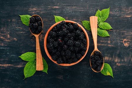 新鲜浆果黑莓。在黑色的木质背景。顶部视图。文本的可用空间