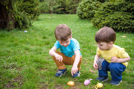 在盛开的复活节彩蛋上的孩子们春天花园。儿童枯萎