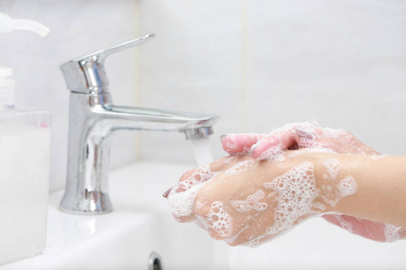 用肥皂在水龙头下洗手