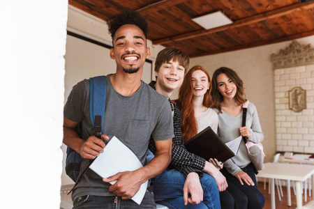 教室里的同学形象开朗的一群同学在教室里抱着文件夹看书.看相机照片