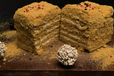 甜自制蜂蜜蛋糕和 truffeles 在一张黑木桌上
