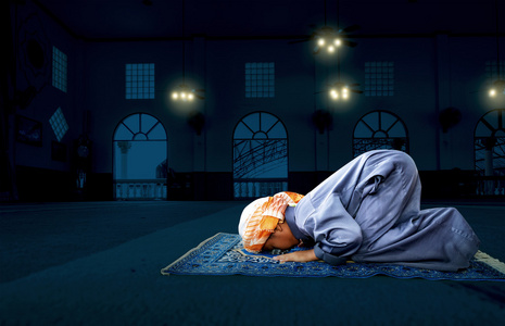 祈求真主在清真寺上的穆斯林儿童摄影图