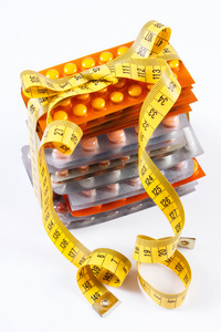 水泡的医疗药片和胶囊包裹厘米 卫生保健健康的生活方式和减肥概念