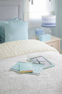 淡蓝色计划卧室内床上的蓝色笔记本