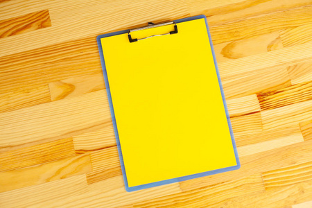 带黄色纸张的空白文件夹。手, 持有文件夹和处理的木材背景。Copyspace。文本位置