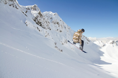 滑雪板骑手跳跃于群山之巅。极端的滑雪随心所欲的运动