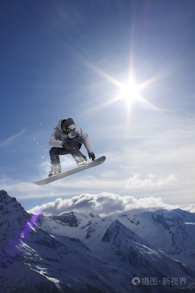 滑雪板骑手跳跃于群山之巅.极端的滑雪随心所欲的运动