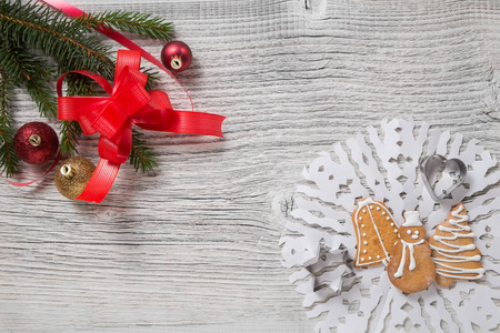 圣诞装饰。松树树枝, 球, 红丝带和姜饼饼干在一个白色的木桌上。文本的空白空间