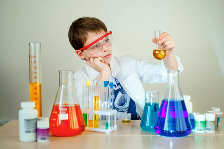 可爱的男孩在实验室里做科学实验照片