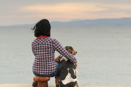 女人和她的狗打击海看日落