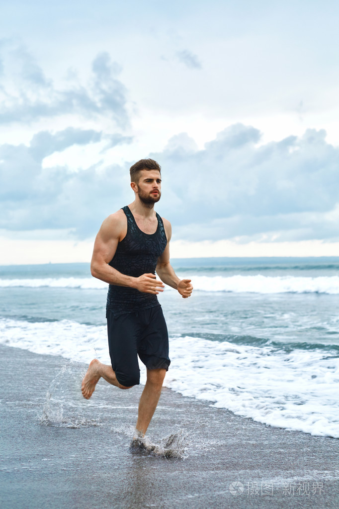 运行在室外健身锻炼在海滩上慢跑的男人.体育
