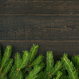 圣诞背景与冷杉分行在木质背景平躺和顶部的看法。圣诞花框装饰与复制空间。新年贺卡创意圣诞树边框