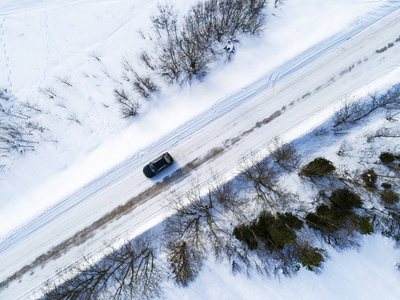 在冬天的路上, 一辆汽车的鸟瞰图。冬季景观乡村。空中摄影的雪林与汽车在路上。从上面捕获的无人机。空中照片。Quadcopter