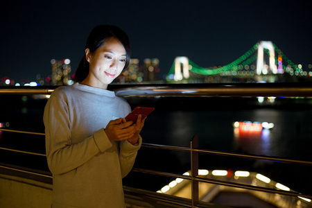 在夜间使用移动电话的女人