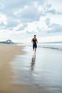 运行在沙滩上，在室外锻炼慢跑的人。体育