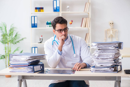 在医院工作太多的忙碌的医生照片