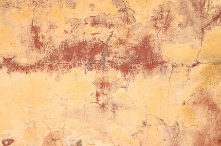 老破旧黄色红色墙体的裂缝。纹理背景