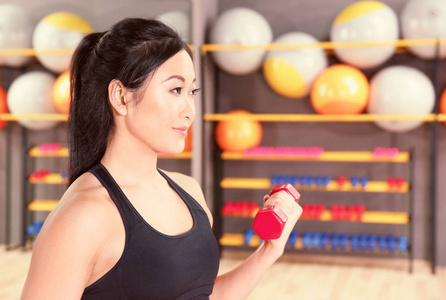 女人用哑铃在健身房训练