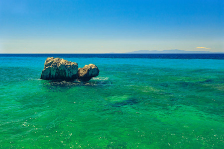 岩石的海岸，俯瞰着绿松石蓝色大海在温暖的夏日