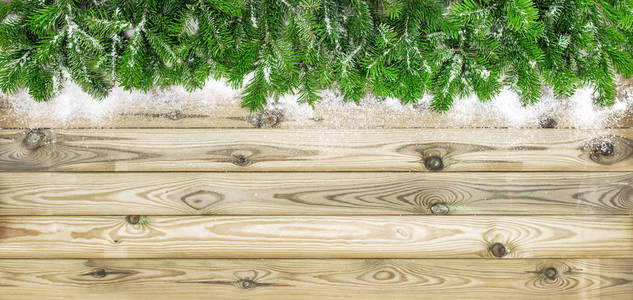 圣诞树的树枝上点缀着雪花的木质质感。冬季假期背景