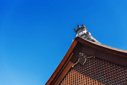 看, 在日本京都, 建筑的木雕屋顶。复制文本的空间。在蓝色背景上被隔离