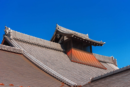 看, 在日本京都, 建筑的木雕屋顶。复制文本的空间。在蓝色背景上被隔离