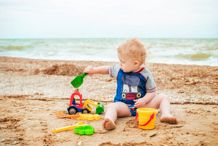小男孩在海上玩玩具。儿童操作系统夏天在海滩上度假