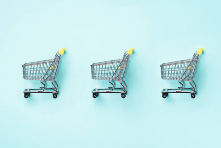 购物车在蓝色背景.简约风格.创意设计.具有复制空间的顶部视图.