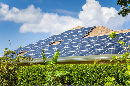 在屋顶上的太阳能电池板太阳能光伏屋顶与工人步行日落时的屋顶太阳能