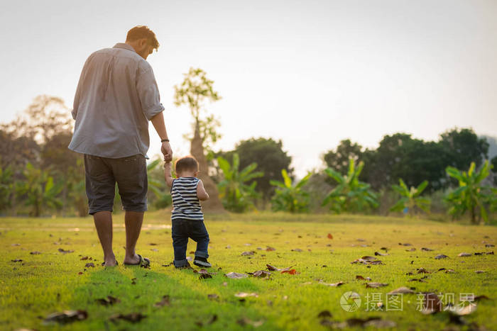 快乐的父亲,在夏天公园散步的小男孩.通过和
