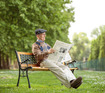 高级坐在公园里读报纸