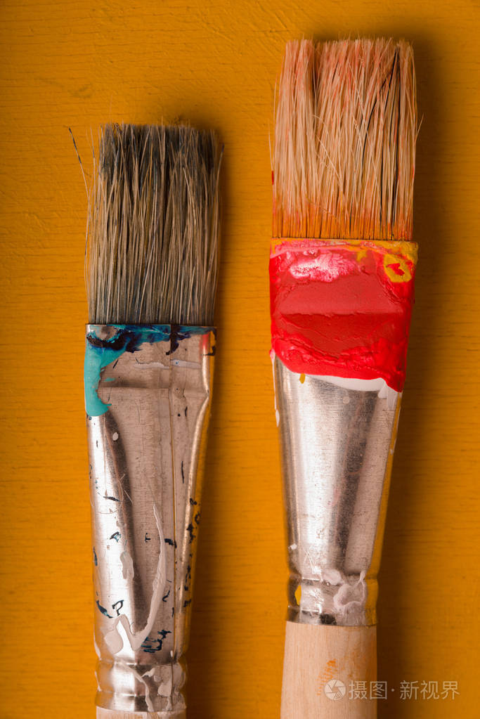 油漆刷在黄色背景上垂直