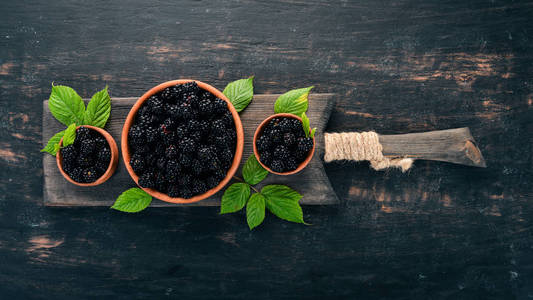 新鲜黑莓在盘子里。在黑色背景上。顶部视图。文本的可用空间