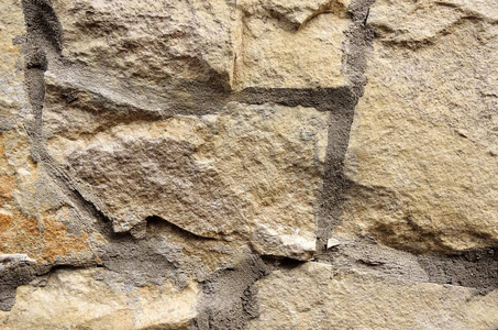 墙是用不同形状的米色石头制成的。